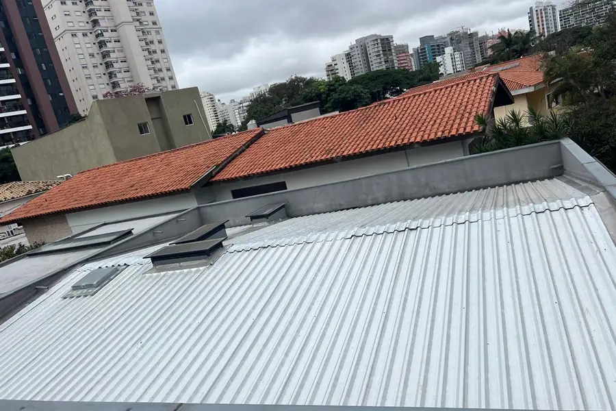 Cobertura combinando telha metálica branca e telhado cerâmico no mesmo imóvel
