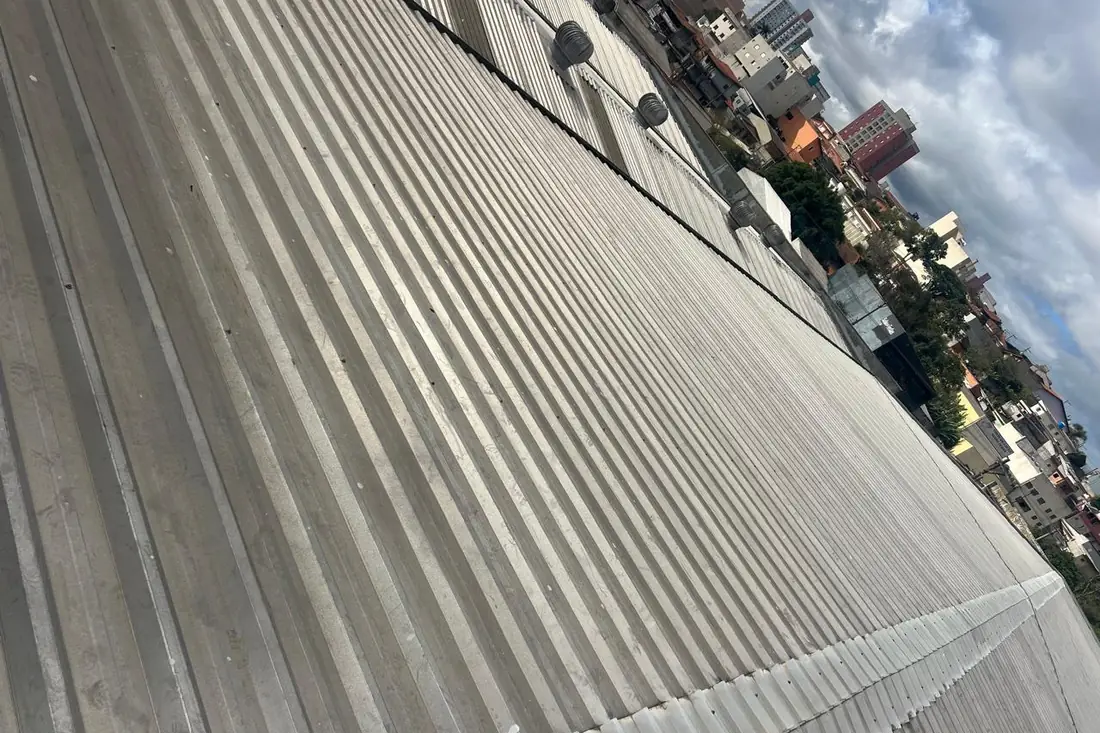 Cobertura metálica de galpão em perspectiva, com telhas onduladas alinhadas